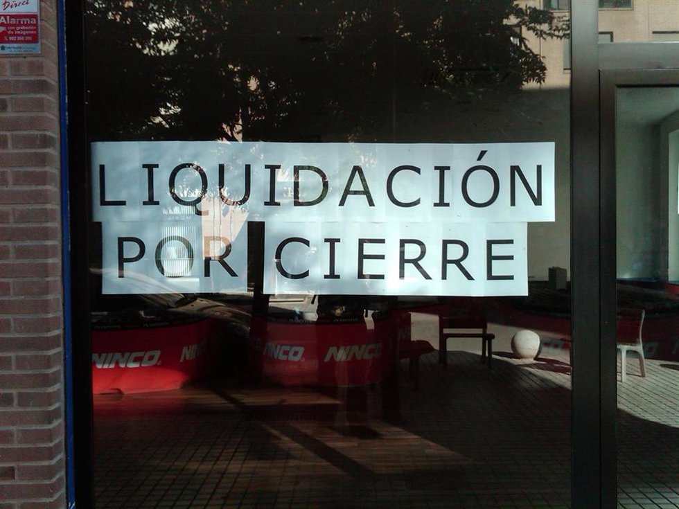 Archivo - Cartel de liquidación por cierre en un establecimiento comercial