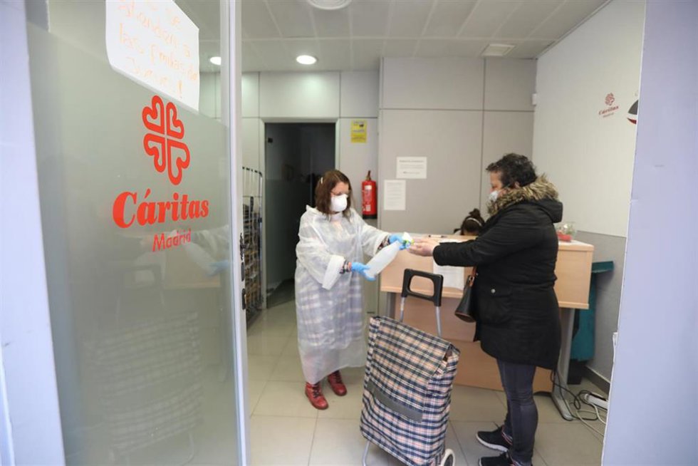 Archivo - Una voluntaria atiende a una mujer en un centro de Cáritas Madrid.