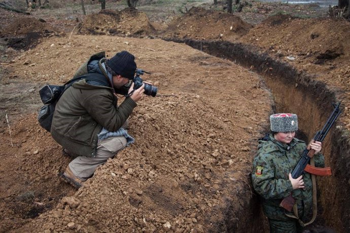 Archivo - El periodista Ángel Sastre toma una fotografía a una cosaca ucraniana