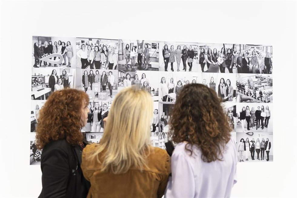 Tres mujeres observan algunas de las fotografías de la segunda edición de la exposición fotográfica Las mujeres del agua.