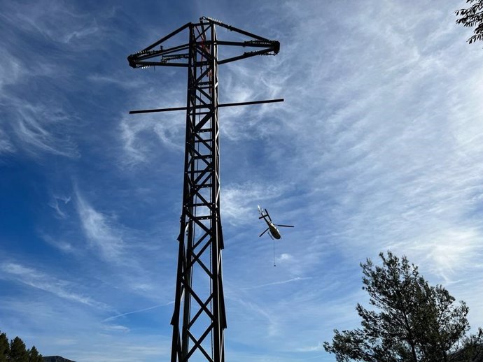 Un helicóptero sobrevuela una de las torres de suministro eléctrico restablecidas en Mallorca.