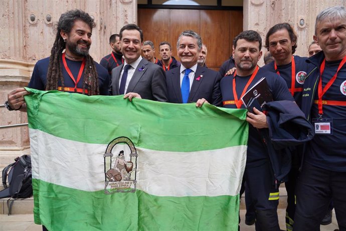 El presidente de la Junta de Andalucía, Juanma Moreno,y el consejero de la Presidencia, Antonio Sanz, posan con bomberos tras la aprobación este miércoles de la Ley de Gestión de Emergencias de Andalucía. 