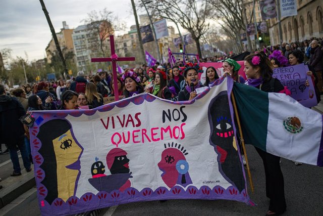 Diverses dones protesten amb un cartell durant la manifestació