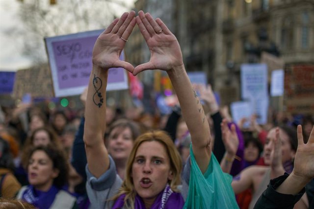 Una mujer hace un símbolo feminista con las manos durante la manifestación de Barcelona