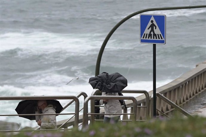 Archivo - Dos personas con paraguas caminan por el Paseo Marítimo de La Coruña, a 19 de junio de 2022, en A Coruña, Galicia, (España). La inestabilidad se mantendrá en Galicia al menos hasta la mitad de la semana que viene. A partir de mañana lunes 20 d