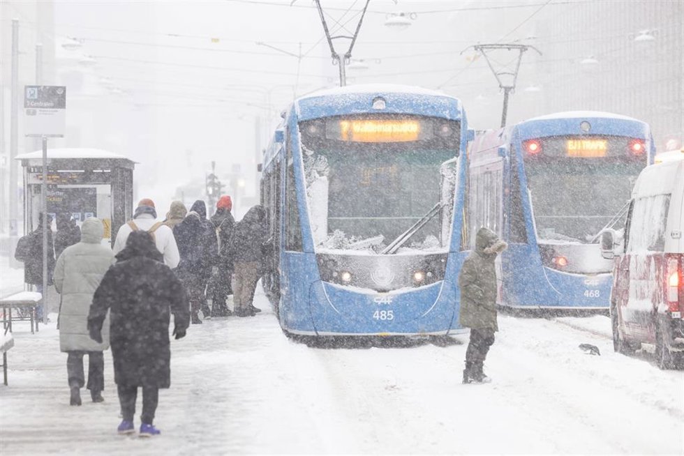Personas junto a tranvías en Estocolmo (Suecia) tras una nevada