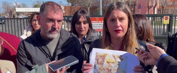 La portavoz de UP y candidata a la Presidencia de la Comunidad de Madrid, Alejandra Jacinto, muestra una fotografía con la comida ofrecida a los residentes de la 'Francisco de Vitoria' de Alcalá de Henares.