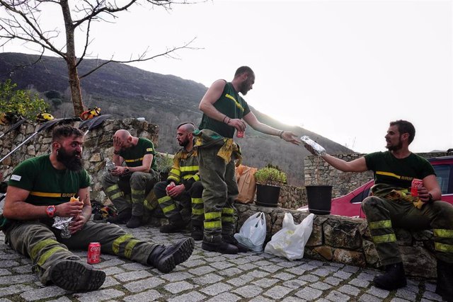 Varios bomberos de las Brigadas de Refuerzo en Incendios Forestales (BRIF) de Cantabria descansan tras las labores de extinción de un incendio forestal en el valle de Ardisana, a 10 de marzo de 2023, en Llano, Asturias (España). 