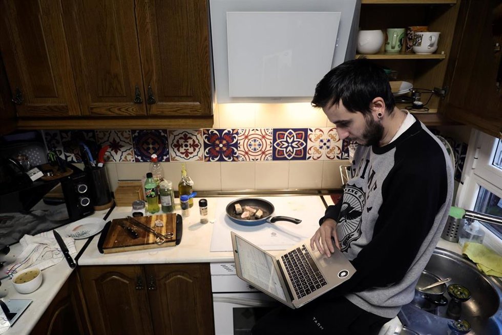 Archivo - Una persona teletrabaja en la cocina de su domicilio.