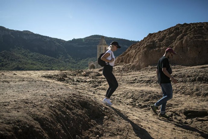 Archivo - Dos personas cerca de la iglesia del antiguo pueblo de Sant Rom en el pantano de Sau, a 3 de octubre de 2022, en Vilanova de Sau, Barcelona, Catalunya (España). El pantano de Sau, con un 30 % aproximadamente de su capacidad debido a la gran s