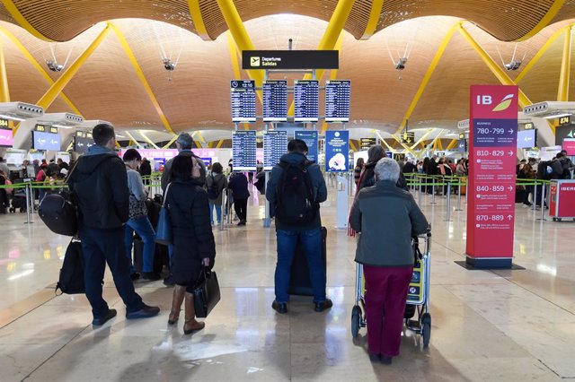 Archivo - Varias personas esperan para embarcar y facturar en la zona de salidas de la Terminal 4 del Aeropuerto Madrid-Barajas Adolfo Suárez