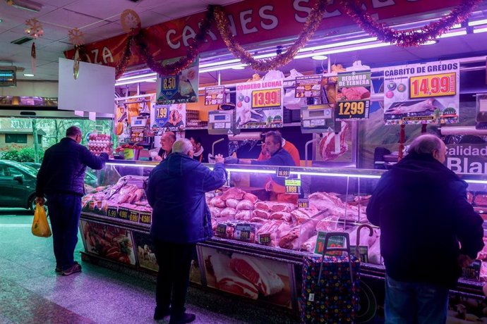 Archivo - Varias personas realizan sus compras en una tienda de comestibles, en una imagen de archivo.