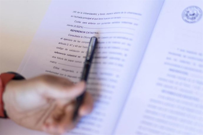 Archivo - Una mujer con un bolígrafo, señala una escritura de compraventa de una hipoteca, a 30 de mayo de 2022, en Madrid (España).