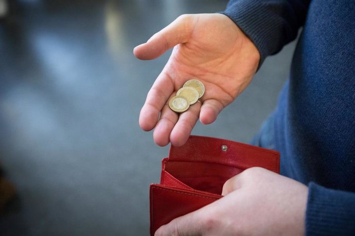 Archivo - FILED - 31 January 2017, North Rhine-Westphalia, Paderborn: A person takes out coins worth five euros from a wallet. Euro zone inflation hit another record high of 9.1\% in August. Photo: Friso Gentsch/dpa