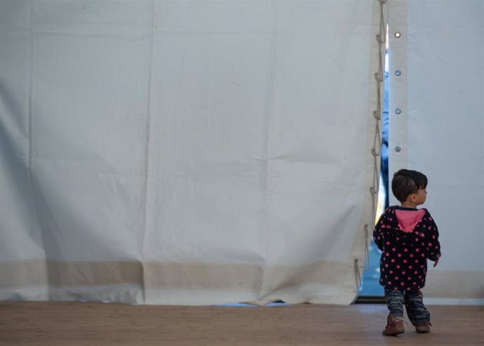 Archivo - Un niño afgano sale de una tienda justo antes de partir hacia Estados Unidos