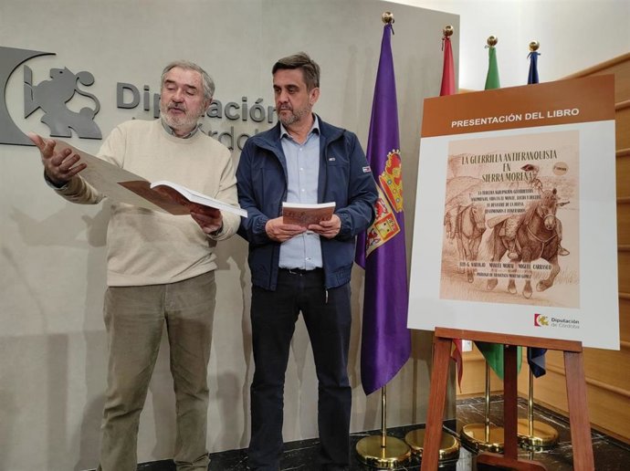 El delegado de Memoria Democrática y Cooperación de la Diputación, Ramón Hernández (dcha.), junto a Luis Naranjo, ojea el libro 'La guerrilla antifranquista en Sierra Morena'.