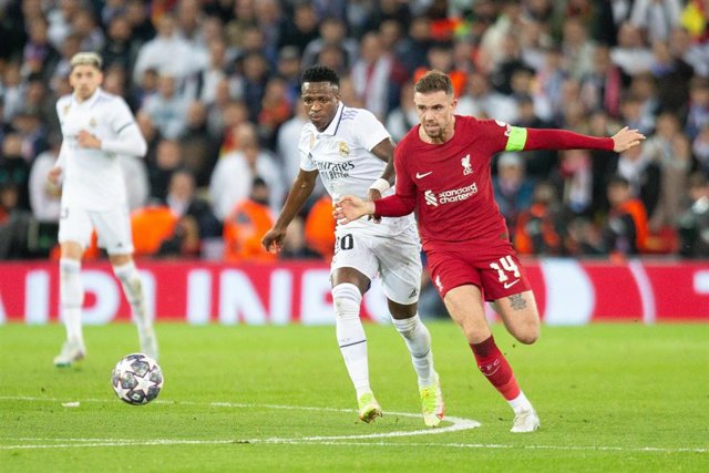 El delantero del Real Madrid Vinicius Júnior y el centrocampista del Liverpool Jordan Henderson disputan un balón, en la ida de los octavos de final de la Liga de Campeones 2022-2023 en Anfield. 