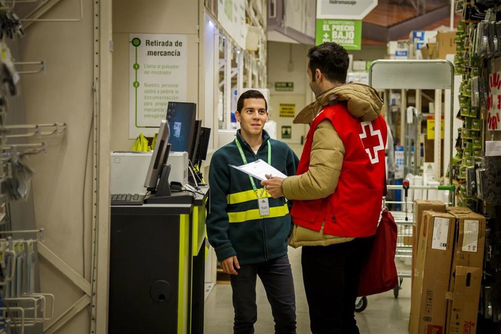 Un trabajador de la Creu Roja habla con un empleado de Leroy Merlin.