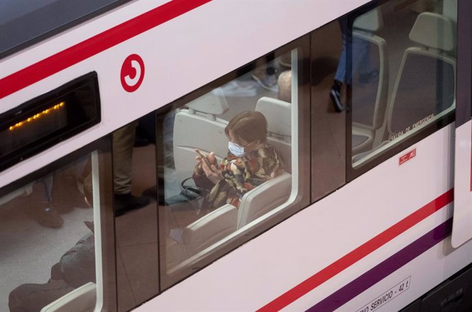 Archivo - Una mujer con mascarilla dentro de un tren de Cercanías