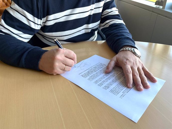 Archivo - Una persona firma un contrato de trabajo