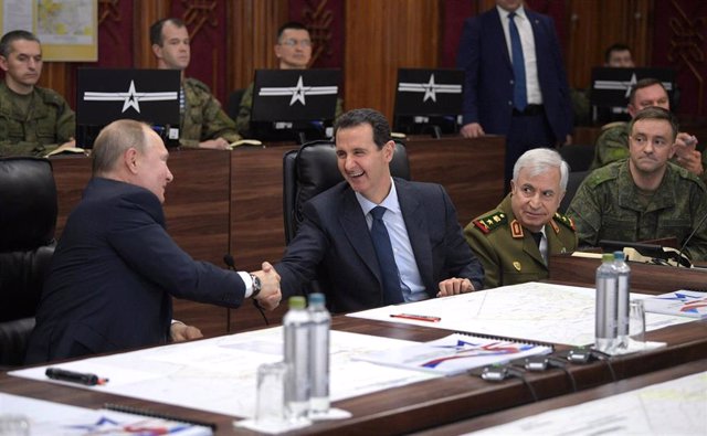 Archivo - El presidente de Rusia, Vladimir Putin (I), tiende la mano a su par sirio, Bashar al Assad (D)
