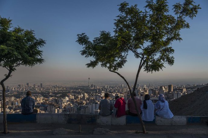 Archivo - 27 May 2022, Iran, Tehran: Iranians sit by the "roof of Tehran" (Bam-e Tehran) and look out over the metropolis. Photo: Arne Bnsch/dpa