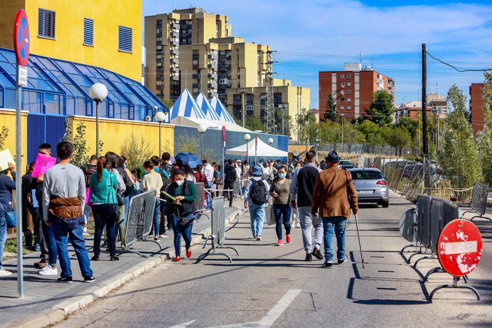 Archivo - Varias personas esperan en una cola para tramitar papeles de Extranjería en el Centro de Internamiento de Extranjeros (CIE) de Aluche tras su reapertura esta semana con el internamiento de 46 argelinos después de medio año cerrado por la pande