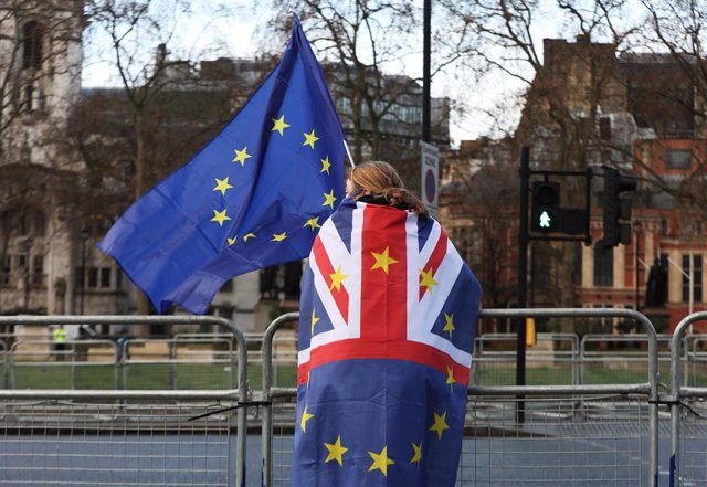 Archivo - Ciudadano en Londres con banderas de Reino Unido y la Unión Europea