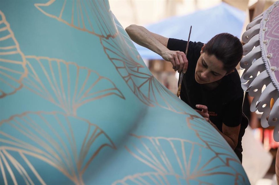 Una artista fallera ultima los detalles de una falla.