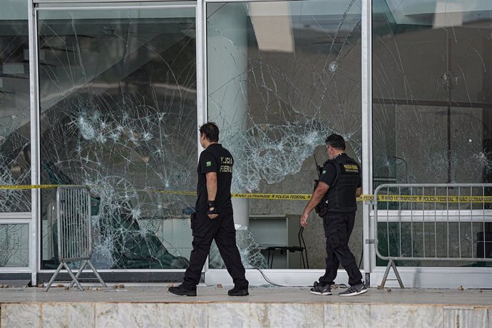 Dos policías supervisan los destrozos de los ataques del 8 de enero en Brasilia.
