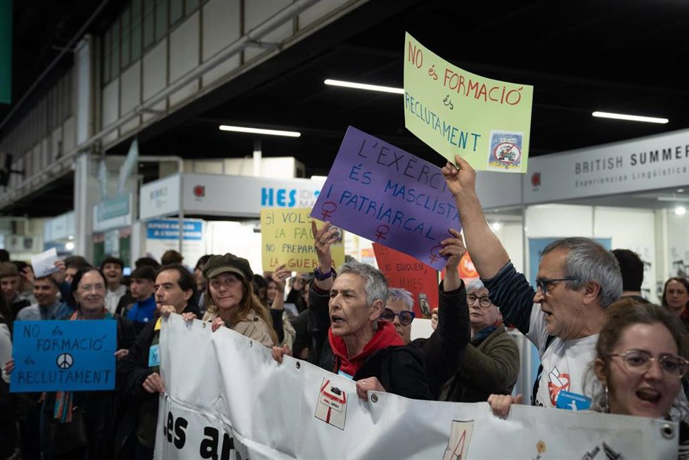 Un grupo de personas sujetando carteles durante una protesta de la plataforma Desmilitaritzem lEducació, en la Fira de Barcelona, a 16 de marzo de 2023, en Barcelona