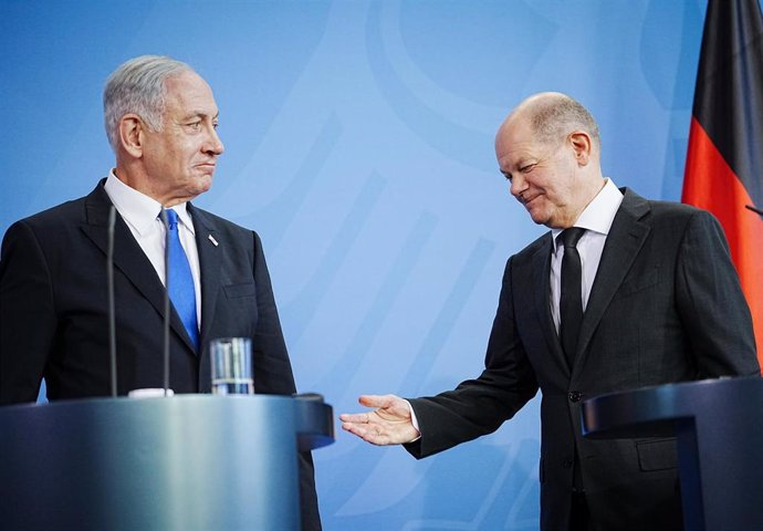 El canciller de Alemania, Olaf Scholz, extiende la mano ante el primer ministro de Israel, Benjamin Netanyahu