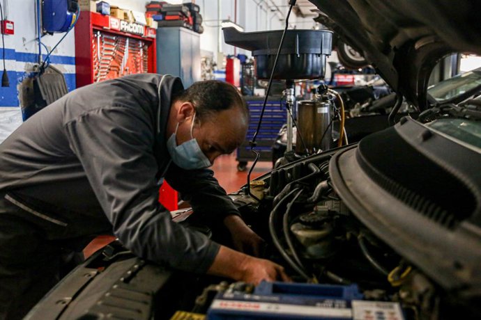 Archivo - Un trabajador con mascarilla arregla un vehículo en talleres Otman, en el polígono industrial Ventorro del Cano en Alcorcón.