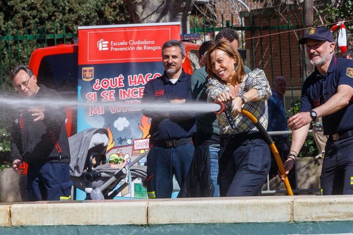 La consejera municipal de Servicios Públicos y Movlidad del Ayuntamiento de Zaragoza, Natalia Chueca, con una manguera del Cuerpo de Bombros
