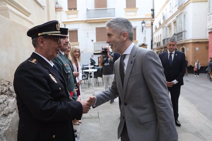 El ministro del Interior, Fernando Grande-Marlaska, (d) saluda a un policía nacional durante la entrega medallas y condecoraciones en el Oratorio de San Felipe Neri, a 16 de marzo de 2023 en Cádiz (Andalucía, España). El ministro de Interior, Fernando G
