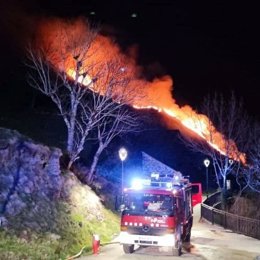 Un vehículo de los servicios de emergencias que participa en la extinción del fuego que este viernes por la mañana quema en Canejan (Lleida)