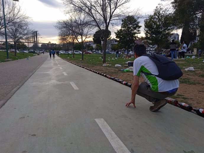 Los voluntarios movilizados por la Plataforma SUMA recogen en el Parque Guadaíra 400 kilos de vidrio. En la imagen, y para visualizar la cantidad de residuos que se dejan, colocan las botellas de cerveza en hilera.