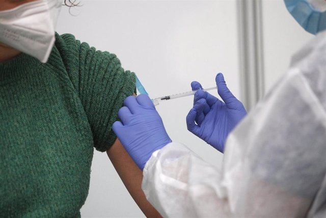 Archivo - Un empleada sanitaria suministra la vacuna contra la Covid-19 en el dispositivo de Germans Escales. Archivo. 