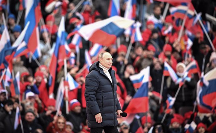 Archivo - FILED - 18 March 2022, Russia, Moscow: The crowd waves Russian flags as Russian President Vladimir Putin walks to deliver a speech during a concert held to mark the eighth anniversary of Russia's annexation of Crimea at the Luzhniki stadium. P