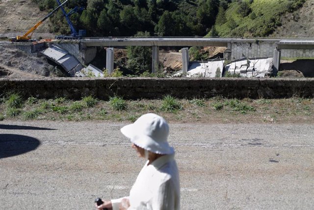 Archivo - Una mujer camina por la carretera mientras se realiza el desmontaje de las pilas 1 y 2 del viaducto de O Castro, en el kilómetro 430 sentido A Coruña de la autovía A-6, en Vega de Valcarce, a 21 de septiembre de 2022, en Vega de Valcarce, León, 