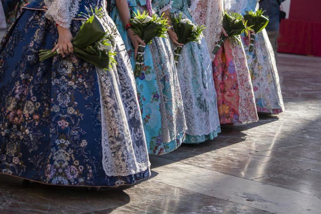 Vestidos y ramos de falleras durante el desfile de la Ofrenda floral a la Mare de Déu dels Desemparats
