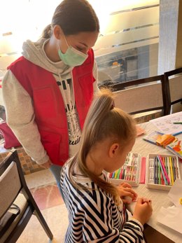 Voluntaria de Cruz Roja prestando asistencia a una niña ucraniana.