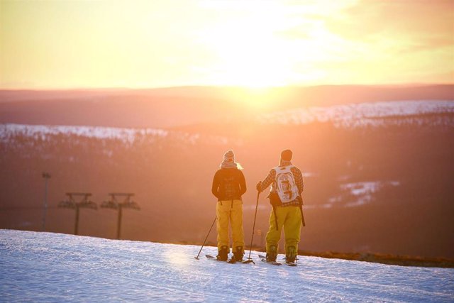 Archivo - Dos esquiadores observan el amanecer en Kolari, Finlandia