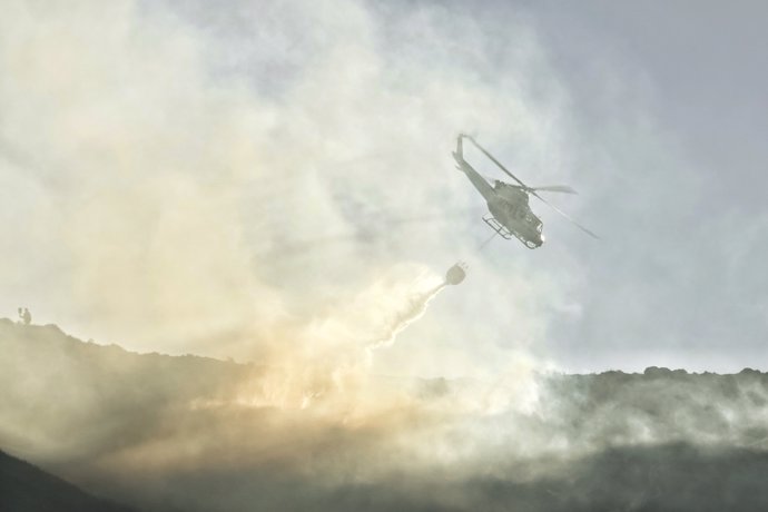 Un helicóptero de las Brigadas de Refuerzo en Incendios Forestales (BRIF) de Cantabria trabaja en las labores de extinción de un incendio forestal en el valle de Ardisana, a 10 de marzo de 2023, en Llano, Asturias (España). 