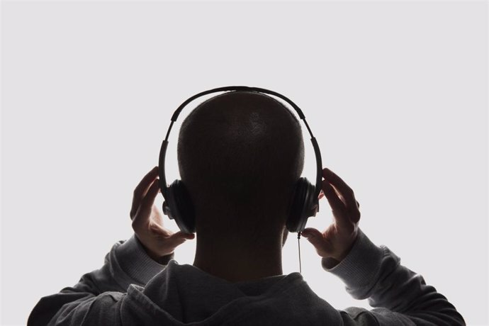 Archivo - Un joven escucha música con cascos