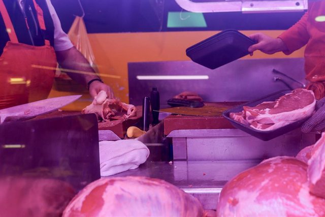 Archivo - Un carnicero realiza sus últimas ventas en Navidad