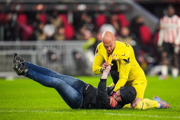 Un aficionado del PSV neerlandés intenta agredir al portero del Sevilla FC Marko Dmitrovic, en un partido de la Liga Europa 2022-2023. 