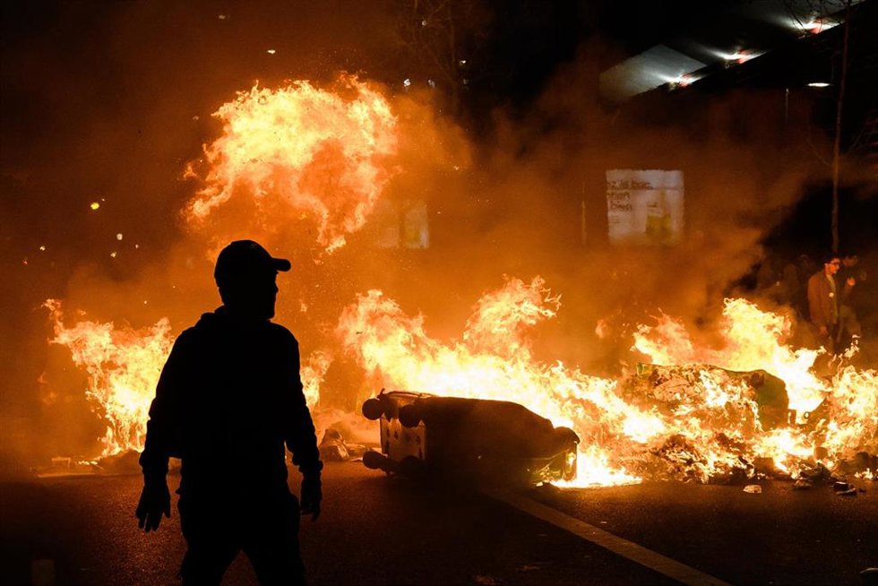 Contenedores incendiados durante las protestas contra la reforma de las pensiones en París, Francia
