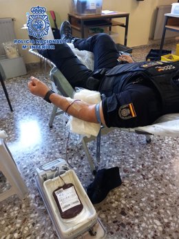 Un agente de la Policía Nacional, durante la donación