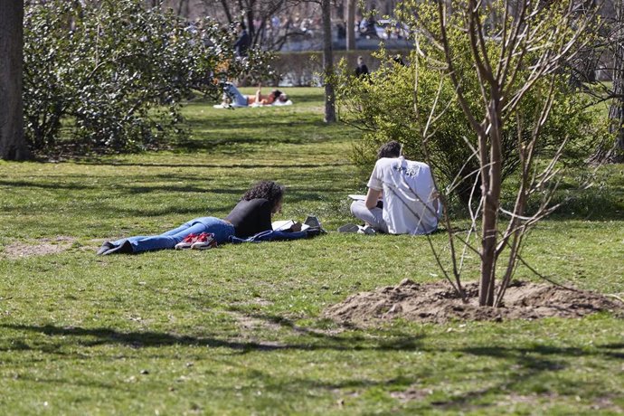 Una pareja lee en el Parque del Retiro, a 11 de marzo de 2023, en Madrid (España). La masa de aire de este fin de semana sobre España procede del océano Atlántico de latitudes inferiores a los 30N. Esta masa de aire cálida, unida a las altas presiones 